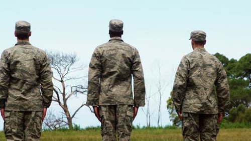 Men in Military Uniform Standing on Grassy Field