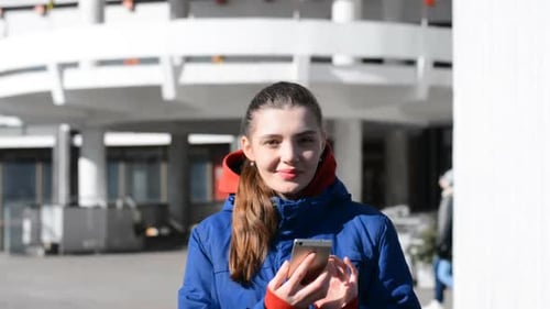 Woman Using Smartphone in Front of Urban Building