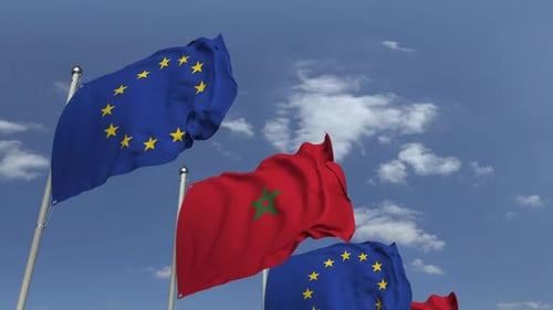Morocco and European Union Flags Waving Against Blue Sky