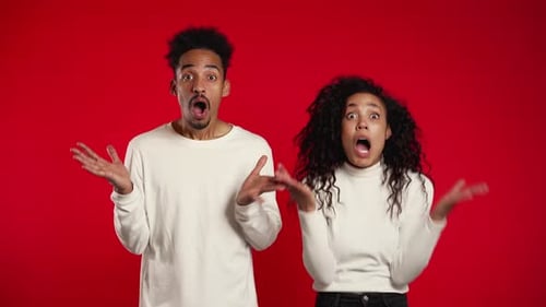 Erstaunter afroamerikanischer Mann und Frau schockiert, WOW sagen. Junges Paar