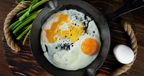 The Frying Pan with Fried Eggs Slowly Rotates on Tray.