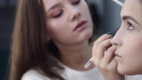Applying Makeup to a Young Woman in Studio