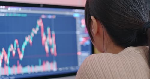 Woman check on stock market data at the screen of computer