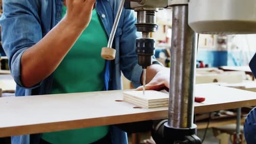 Woman Using Drill Press in Bright Workshop