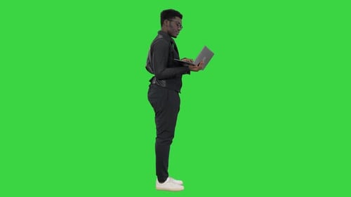 Confident African American Businessman Typing on Laptop on a Green Screen, Chroma Key