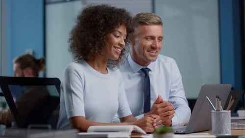 Businessman and Businesswoman Showing Thumbs Up During Video Call on Laptop