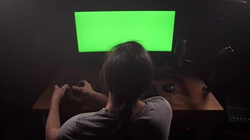 Ein Mann im Kopfhörer schaut auf den grünen Bildschirm des Monitors, entfernt die Kopfhörer, schaut auf den