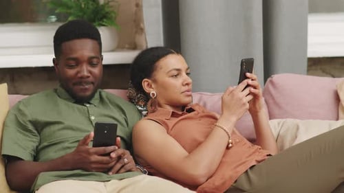 Couple Relaxing on Couch with Smartphones
