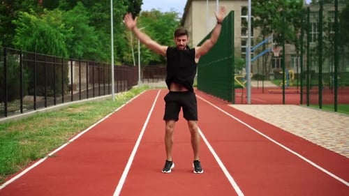 Fit Bearded Man Standing on Running Track Outdoors on Modern Stadium Doing Workout