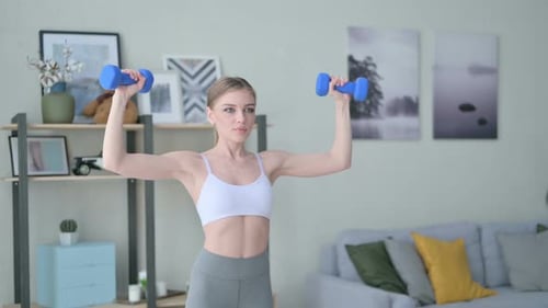 Woman Working Out with Dumbbells in Living Room