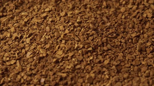 Granules of Instant Coffee Sprinkled on a Plate Closeup Spinning As a Backdground for a Coffee Shop