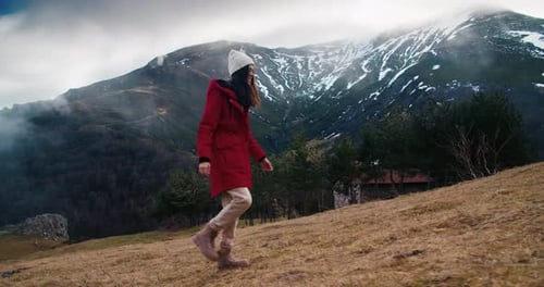 Woman Hiking on Mountain Trail in Red Coat