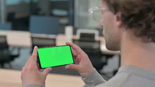 Rear View of Young Businessman Looking at Smartphone with Chroma Screen