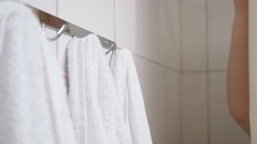 Hand Taking Fresh White Towel in Bathroom