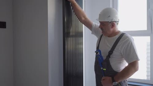A Man Plumber Checks the Batteries and Heating System