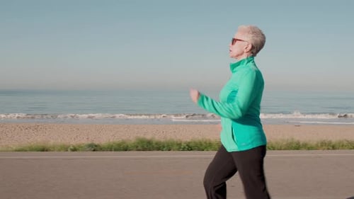 Senior Woman Exercising At The Beach