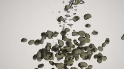 Weiße Kidneybohnen fallen ins Wasser