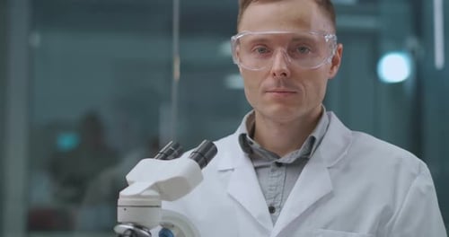 Smiling Male Lab Assistant in Laboratory, Looking at Camera, Scientist and Forensic Expert