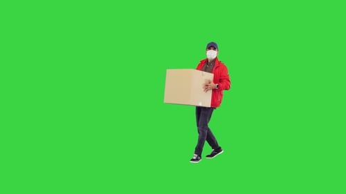 Deliveryman in Medical Mask Leaving a Box and Making a Photo of It on the Smartphone on a Green