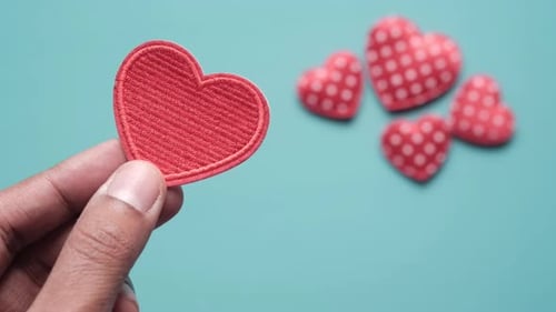 Holding Red Heart Patch on Light Blue Surface
