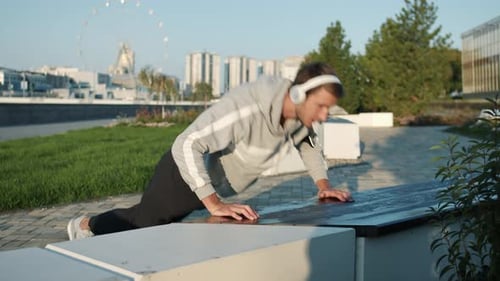 Man Doing Pushups in Urban Park on Sunny Day