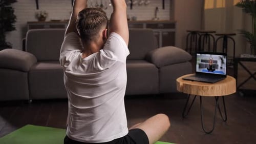 Man Practicing Yoga at Home With Online Class