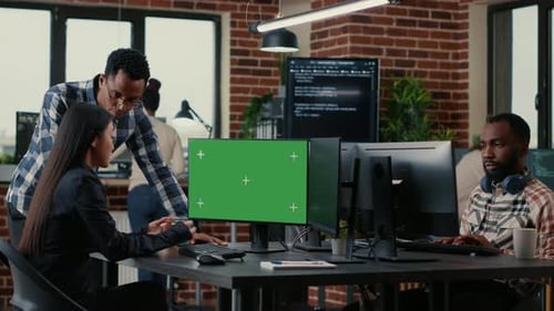 Dois desenvolvedores de software analisando o código-fonte olhando para a maquete de chroma key de tela verde com