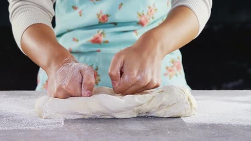 Woman kneading a dough