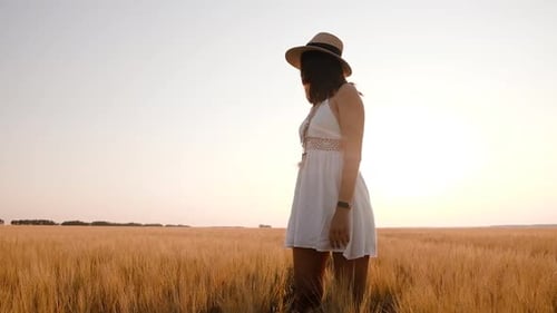 Happy Free Young Woman Dancing and Spinning Around in Slow Motion Across Field Touching Ears of