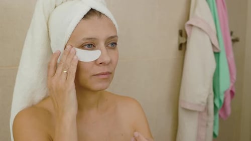 Woman Applying Under Eye Patches in Bathroom