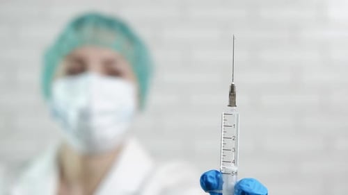 Doktor mit einer Spritze.