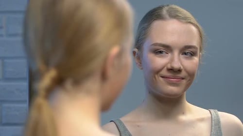 Junge Beauty-Bloggerin schaut in den Spiegel, Luftkuss in die Kamera sendet, Tipps für Mädchen