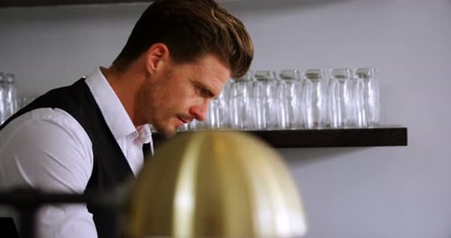 Waiter working at counter in restaurant