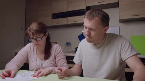 Couple Reviewing Finances at Kitchen Table