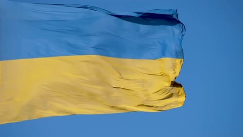 Blue and Yellow Flag Waving Against Blue Sky