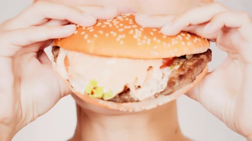 Young Woman Eating a Hamburger Close Up