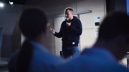 Man Speaking at Corporate Tech Conference with Microphone