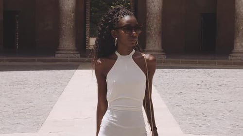 Elegant Woman Takes Photo in Sunny Courtyard