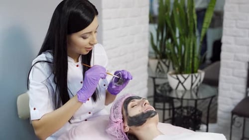 Esthetician Applies Mud Mask to Woman in Spa