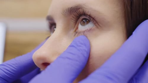 Nahaufnahme einer Patientin mit Augenuntersuchung durch einen Augenarzt