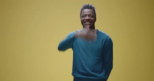 Man Smiles and Makes Funny Faces on Yellow