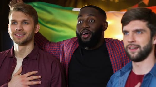 Enthusiastic Friends Cheering with Flag at Night