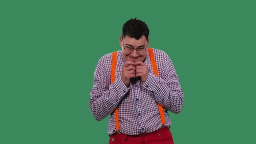 Man with Suspenders Giggling in Front of Green Screen