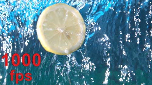 Lemon Slice Falling into Splashing Blue Water