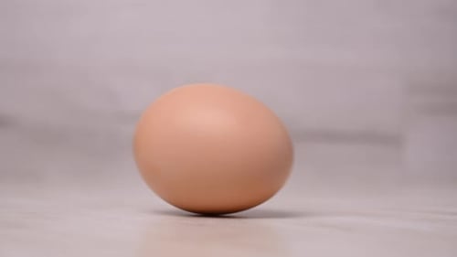 Ein Hühnerei rotiert auf dem Küchentisch. Natürliche Produkte für das Frühstück