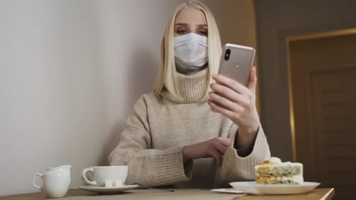 Girl Wear Surgical Protective Face Mask Sitting in Cafe Alone and Social Distancing Lifestyle During