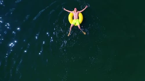 Boy swimming with swim ring. Happy little boy swimming with colorful ring