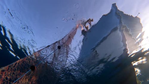 Fishing Net Hanging From Boat Under Sea in Underwater