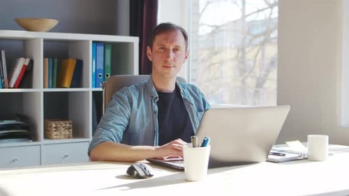 Young male entrepreneur works at home office at the computer.