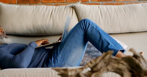 Man Relaxing with Laptop Computer on Sofa